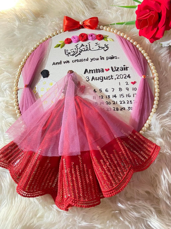 Handmade Hoop Embroidery Art titled "Created in Pairs: Amna & Uzair Wedding Hoop Art" featuring a meaningful quote, names, and intricate floral embroidery, displayed in a hoop.