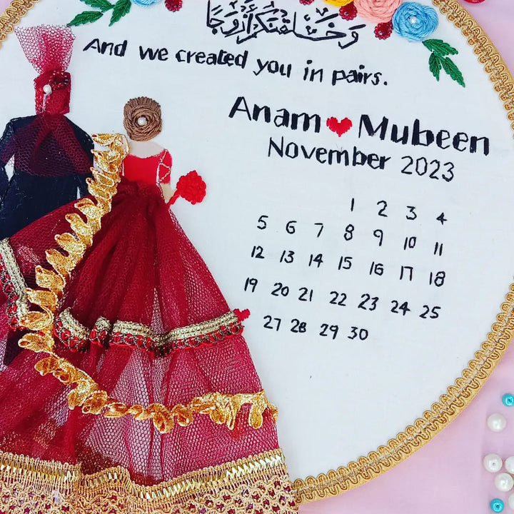 Handmade Hoop Embroidery Art titled "Created in Pairs: Anam & Mubeen Wedding Hoop Art" featuring a meaningful quote, names, and intricate floral embroidery, displayed in a hoop.