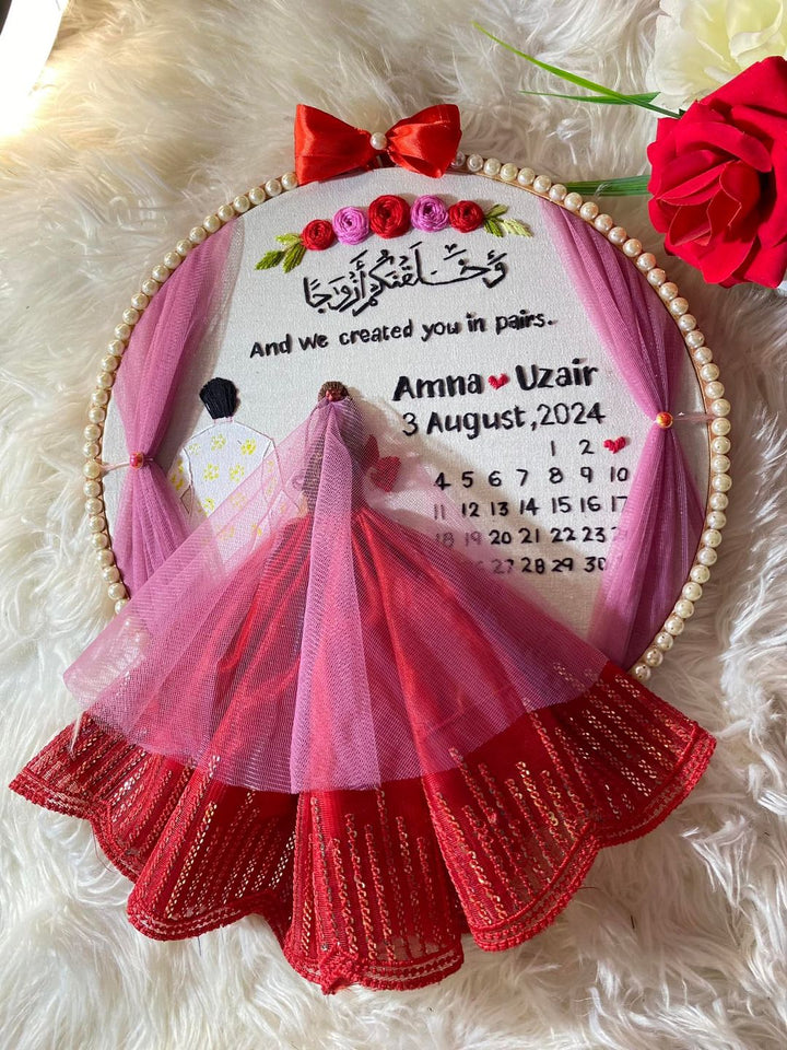 Handmade Hoop Embroidery Art titled "Created in Pairs: Amna & Uzair Wedding Hoop Art" featuring a meaningful quote, names, and intricate floral embroidery, displayed in a hoop.