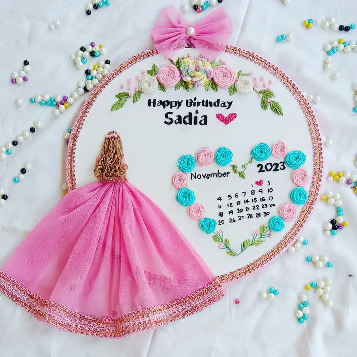 Handmade Hoop Embroidery Art titled "Happy Birthday Sadia" featuring a heartfelt birthday message with intricate embroidery designs, displayed in a standard embroidery hoop.